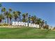 Landscaped entrance to Rhodes Ranch, marked by a sign and framed by mature palm trees at 74 Harbor Coast St, Las Vegas, NV 89148
