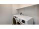 Functional laundry area with modern washer and dryer units, along with convenient overhead shelving at 74 Harbor Coast St, Las Vegas, NV 89148