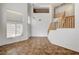 Bright living room with tall windows, a staircase, and neutral flooring at 74 Harbor Coast St, Las Vegas, NV 89148