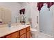 Bathroom featuring a white sink, toilet, decorative mirror and a walk-in shower with tiled walls at 7461 Tahoe Basin Dr, Las Vegas, NV 89129