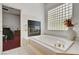 Bright bathroom featuring a tiled tub with a fireplace and decorative window at 7461 Tahoe Basin Dr, Las Vegas, NV 89129