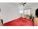Bright bedroom with a ceiling fan, window, red carpet, and some modern furniture at 7461 Tahoe Basin Dr, Las Vegas, NV 89129
