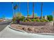 Canyon Ranch Estates entrance featuring brick signage, lush landscaping, and mature palm trees at 7461 Tahoe Basin Dr, Las Vegas, NV 89129