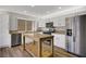 The kitchen features stainless steel appliances, white cabinets and island with butcher block top at 7813 Paper Flower Ct, Las Vegas, NV 89128