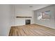 Cozy living room featuring a modern fireplace, wood floors, and a bright window at 7813 Paper Flower Ct, Las Vegas, NV 89128