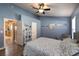 Bedroom with blue walls, wood floors, ceiling fan, and view of the kitchen at 8109 Sunset Mill Dr, Las Vegas, NV 89128