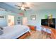 Bedroom with wood floors, blue walls, ceiling fan, and view of the bathroom at 8109 Sunset Mill Dr, Las Vegas, NV 89128