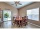 Dining room featuring a dark wood table, chairs, a ceiling fan, and sliding glass door to the backyard at 8109 Sunset Mill Dr, Las Vegas, NV 89128
