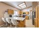 Open kitchen with breakfast bar, granite countertops, wood cabinets, and a skylight at 8109 Sunset Mill Dr, Las Vegas, NV 89128