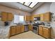 A bright kitchen features a skylight, wood cabinets, stainless steel appliances, and granite countertops at 8109 Sunset Mill Dr, Las Vegas, NV 89128