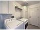 Laundry room with white walls, cabinets, and appliances at 8109 Sunset Mill Dr, Las Vegas, NV 89128