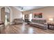 Bright living room with wood floors, fireplace, ceiling fans, and open entryway to adjacent rooms at 8109 Sunset Mill Dr, Las Vegas, NV 89128