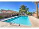 Large swimming pool surrounded by hardscape with mature landscaping in the background at 8109 Sunset Mill Dr, Las Vegas, NV 89128