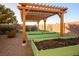 Backyard garden with raised beds ready for planting, set under a pergola and desert landscaping at 8365 S Hauck St, Las Vegas, NV 89139