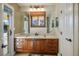 Bright bathroom featuring wood cabinets, a large mirror, and natural light from the window at 8365 S Hauck St, Las Vegas, NV 89139