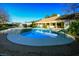 Inviting backyard pool area with mature desert landscaping and covered patio in the background at 8365 S Hauck St, Las Vegas, NV 89139