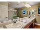 Bathroom with double sinks, tiled countertop, mirrors and a glass-enclosed shower at 8365 S Hauck St, Las Vegas, NV 89139