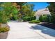 Long driveway leading to a charming home with a meticulously maintained landscape, and mature flowering trees at 8365 S Hauck St, Las Vegas, NV 89139