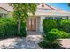 Charming front entrance with a double-door entry surrounded by lush landscaping and a brick walkway at 8365 S Hauck St, Las Vegas, NV 89139