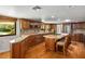 Spacious kitchen featuring wood cabinets, granite countertops, and a large kitchen island with seating at 8365 S Hauck St, Las Vegas, NV 89139