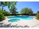 Swimming pool and jacuzzi featuring blue tiling and a concrete deck with trees surrounding the area at 8365 S Hauck St, Las Vegas, NV 89139