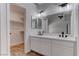 Modern bathroom featuring a double sink vanity, quartz countertops, and a walk-in closet for storage at 887 Cozy Valley St, Henderson, NV 89015