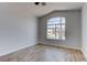 Bright bedroom with a large arched window and wood-look tile flooring, providing a cozy ambiance at 887 Cozy Valley St, Henderson, NV 89015