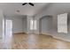 Spacious living room with wood look tile floors, neutral color scheme, and arched doorways at 887 Cozy Valley St, Henderson, NV 89015