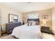 Cozy bedroom with dresser, nightstand, and a queen bed, illuminated by the natural light from the window at 904 Boulder Springs Dr # 102, Las Vegas, NV 89128