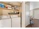 Neat laundry room with stacked washer and dryer units, plus overhead storage shelves, for added convenience at 904 Boulder Springs Dr # 102, Las Vegas, NV 89128