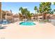 Community pool featuring a spacious deck with lounge chairs and tropical landscaping with palm trees at 904 Boulder Springs Dr # 102, Las Vegas, NV 89128