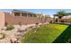 View of backyard featuring grass, desert landscaping, and covered patio at 945 Stetson Dr, Henderson, NV 89002