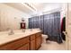 Bathroom with double sinks, wood cabinets, and shower/tub with curtain at 945 Stetson Dr, Henderson, NV 89002