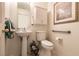 Bright bathroom featuring a pedestal sink, toilet, and framed art at 945 Stetson Dr, Henderson, NV 89002