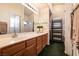 Bathroom featuring a double sink vanity, mirror, and tiled countertops at 945 Stetson Dr, Henderson, NV 89002