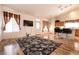 Open living room featuring wood floors, a modern TV, and a cozy floral area rug at 945 Stetson Dr, Henderson, NV 89002