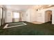 Spacious living room with green carpet, neutral walls, and double-door closet at 945 Stetson Dr, Henderson, NV 89002