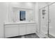Modern bathroom with dual sinks, white cabinetry, and a glass-enclosed walk-in shower at 9714 Harper Edge St, Las Vegas, NV 89143