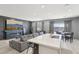 Open-concept living room features a modern fireplace, TV and a spacious gray sectional couch at 9714 Harper Edge St, Las Vegas, NV 89143