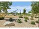 Community playground featuring swings, slides, and climbing structures surrounded by lush landscaping and trees at 9714 Harper Edge St, Las Vegas, NV 89143