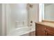 This bathroom features a clean white tiled tub and shower combination and a vanity with granite countertop at 10085 S Riley St, Las Vegas, NV 89178