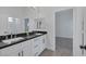 Modern bathroom with dual sinks, sleek black countertops, and a spacious vanity offering ample storage at 10113 Plomosa Pl, Las Vegas, NV 89134