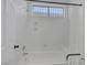 Bright bathroom featuring a shower over tub with window, white walls and shower curtain at 10113 Plomosa Pl, Las Vegas, NV 89134