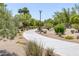 Community path surrounded by lush greenery and desert landscaping in a peaceful setting at 10113 Plomosa Pl, Las Vegas, NV 89134