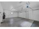 Spacious garage with three overhead doors, concrete floor, and overhead lighting at 10113 Plomosa Pl, Las Vegas, NV 89134