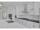 Modern kitchen with white cabinets, marble backsplash, stainless appliances and a large center island at 10113 Plomosa Pl, Las Vegas, NV 89134