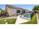 Backyard showcases a fenced swimming pool, desert plants, solar panel and grass at 10113 Plomosa Pl, Las Vegas, NV 89134