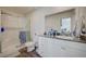 Modern bathroom with a granite countertop vanity, white cabinets, and a walk-in shower with glass doors at 1131 Ruby Sparrow St, Henderson, NV 89011