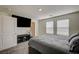 Bedroom featuring carpet floors, two windows, and a large TV at 1131 Ruby Sparrow St, Henderson, NV 89011
