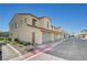 Street view of the townhome showcasing stucco exterior, tile roof, and attached garages at 1131 Ruby Sparrow St, Henderson, NV 89011